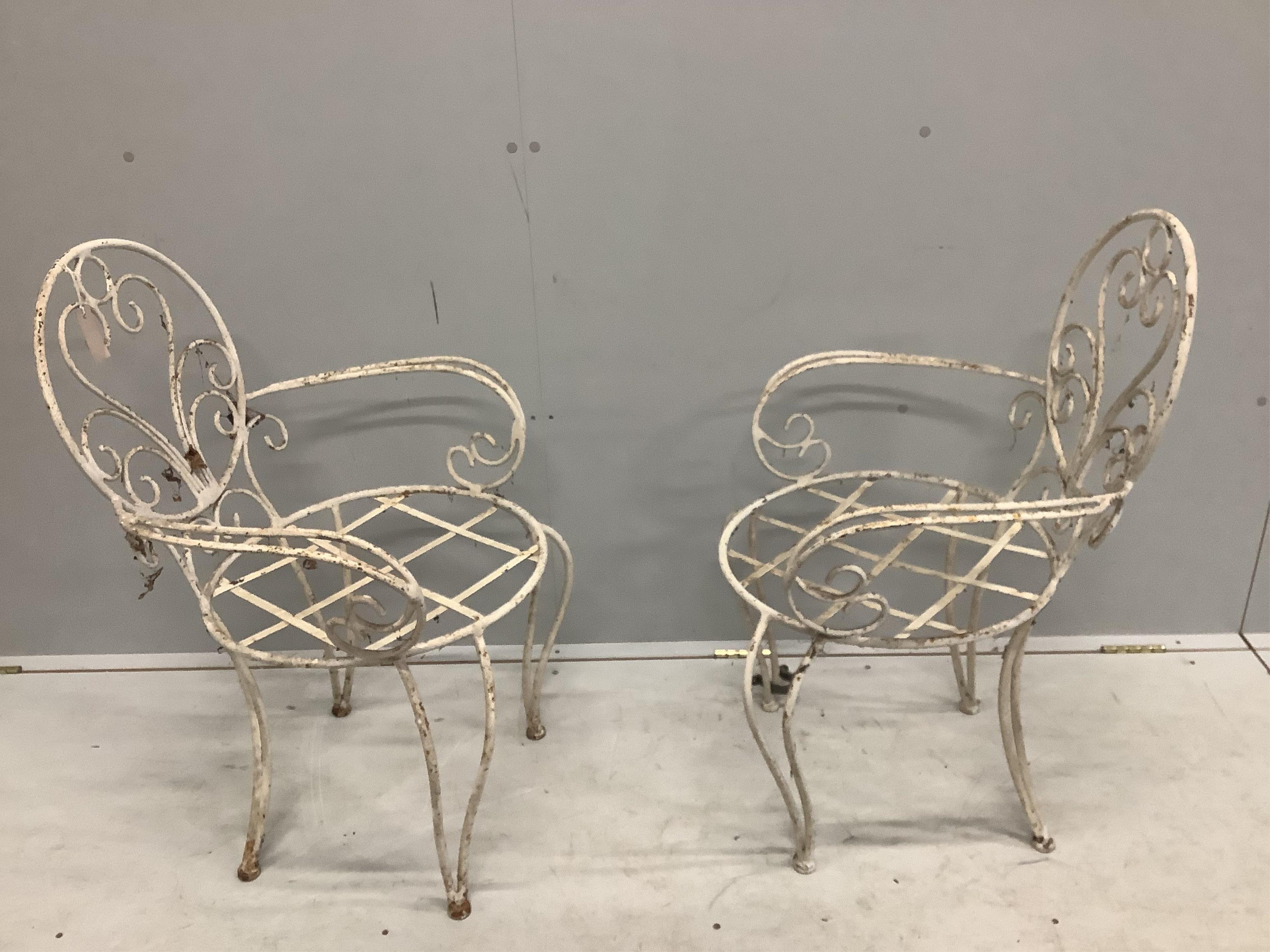 A pair of vintage wrought iron garden chairs, width 53cm, depth 46cm, height 85cm. Condition - poor to fair